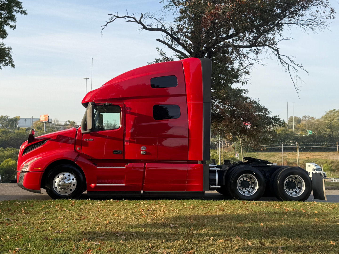 2022 Volvo VNL64T760 tractor truck profile showing red exterior, sleeper cab, and dual rear axles.