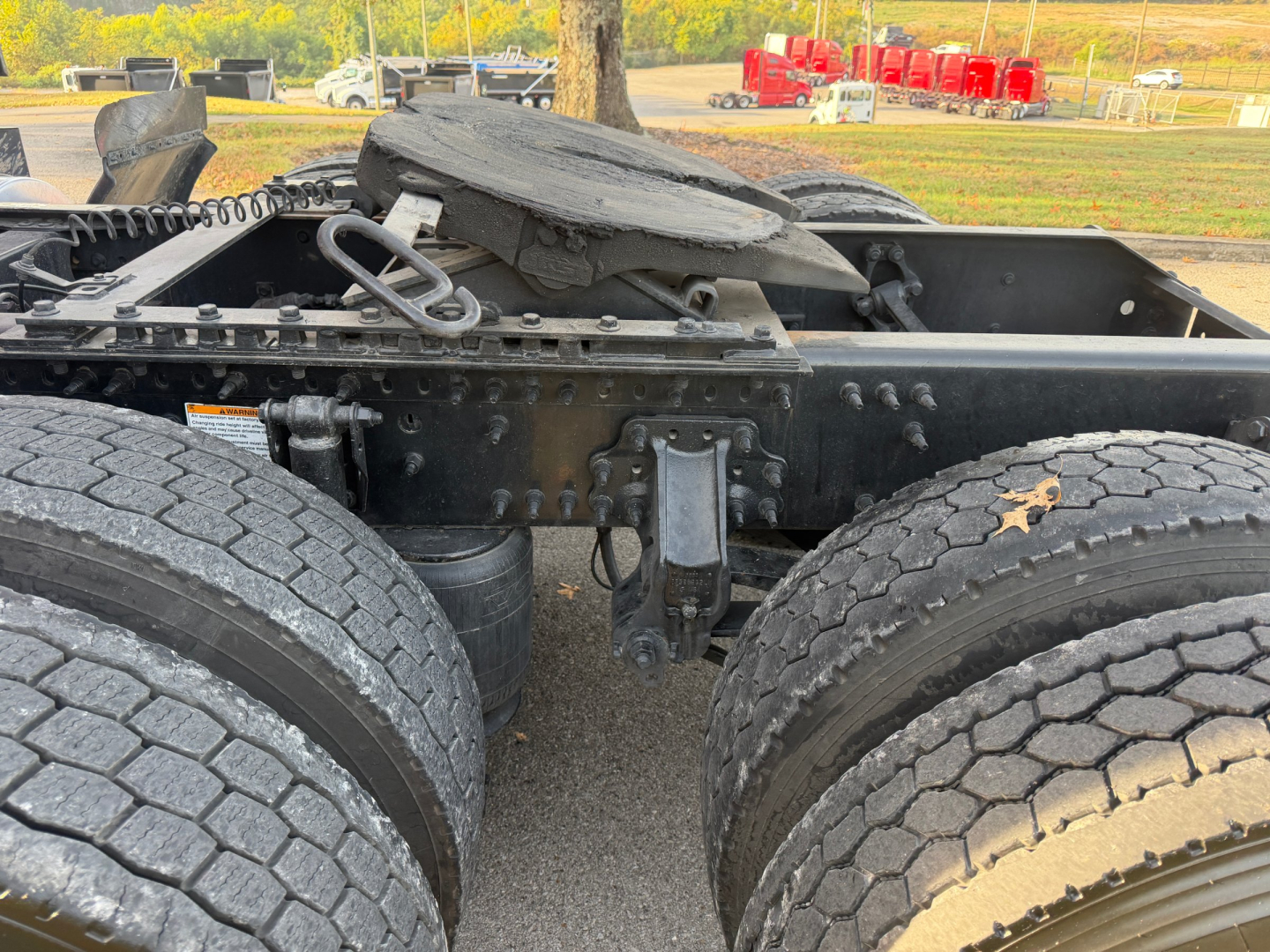 Volvo VNL64T760 truck chassis showing wheel hubs and fifth wheel coupling with oil/dirt, no visible labels.