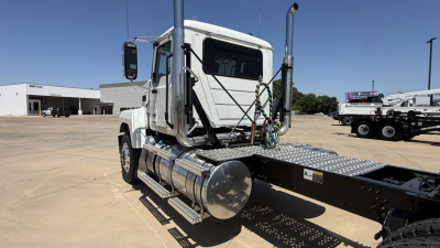 Mack PI64T truck cab and chassis showing fuel tank and back of cab with steps and safety rails.