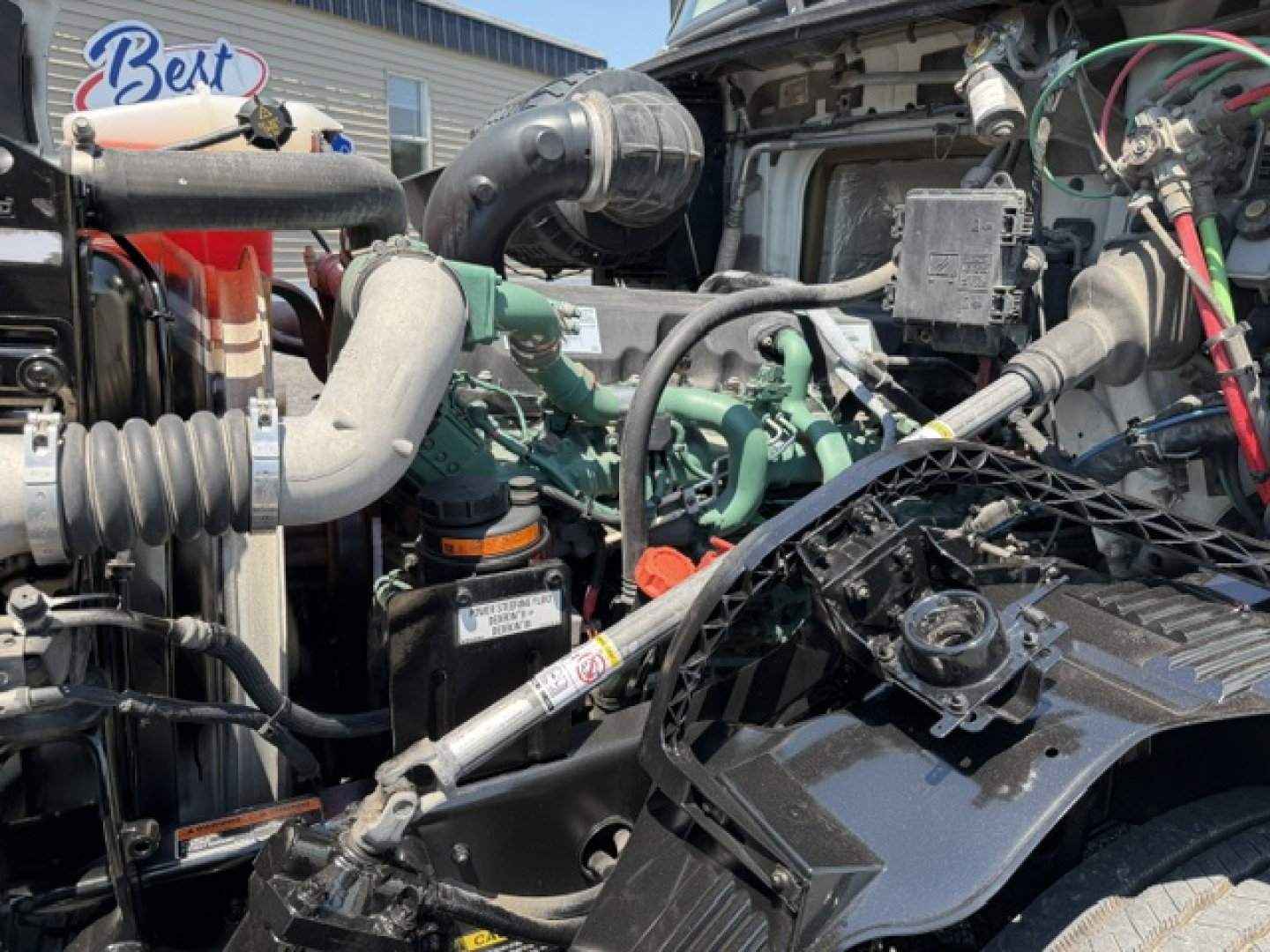  Volvo VNL64T300 engine bay showing engine components, hoses, and wiring in a truck bay.