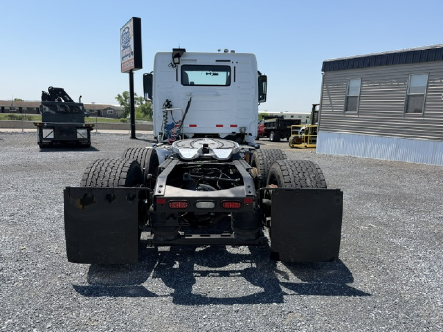 Rear view of a used 2016 Volvo VNL64T300 day cab with dual rear wheels and mud flaps, showing chassis and fifth wheel area.