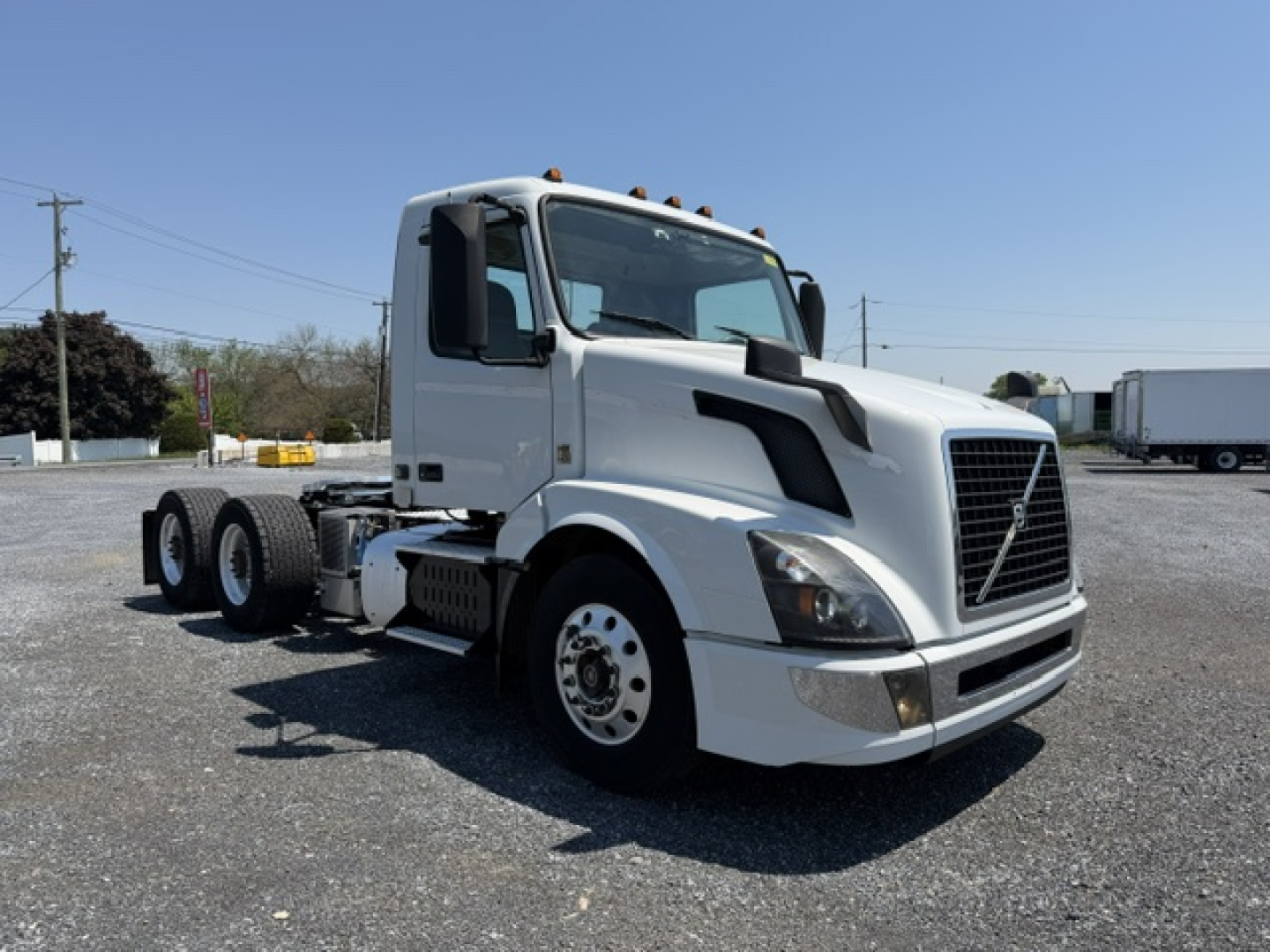 2016 Volvo VNL64T300 truck showing front and side view, white cab, daytime running, standard grille and wheel configuration.