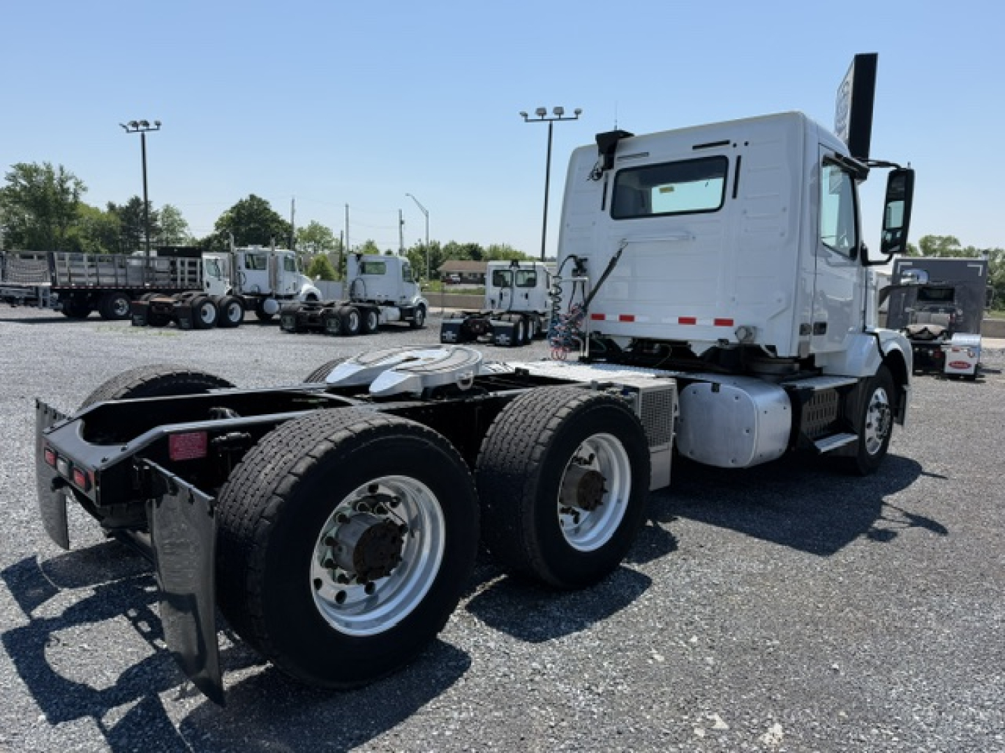 Vehicle: 2016 Volvo VNL64T300 truck in a lot, rear chassis with dual rear axles and fifth wheel, white cab, no visible decals.
