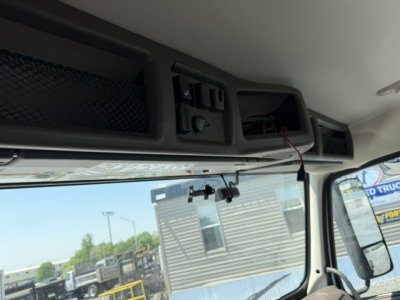 Cab interior showing overhead vent and control panel on Volvo VNL truck dashboard with windshield and side mirror.