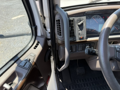 Cab interior of a 2016 Volvo VNL64T300 truck showing steering wheel, dashboard gauges, and driver-side door panel.