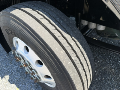 Wheel and tire close-up on a Volvo VNL64T300 truck showing front dual rear wheel with Rim and lug nuts and tire tread detail.