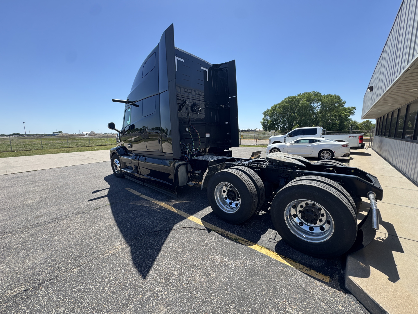 Truck cab and chassis of a new 2027 Mack PR64T76H conventional sleeper with dual rear axles, chrome wheels, and a raised sleeper cab. No identifying stickers readable.