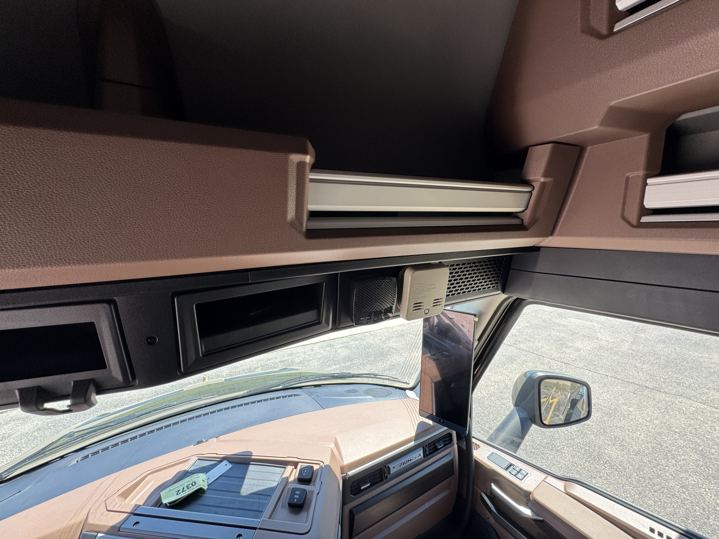 Mack PR64T76H cab interior showing dashboard and overhead storage with text and switches.