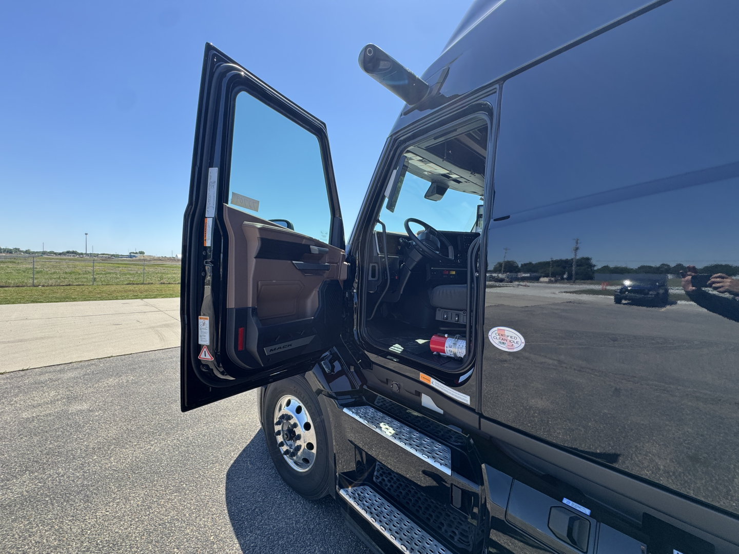New Mack PR64T76H truck cab with open door showing entry steps and interior view.