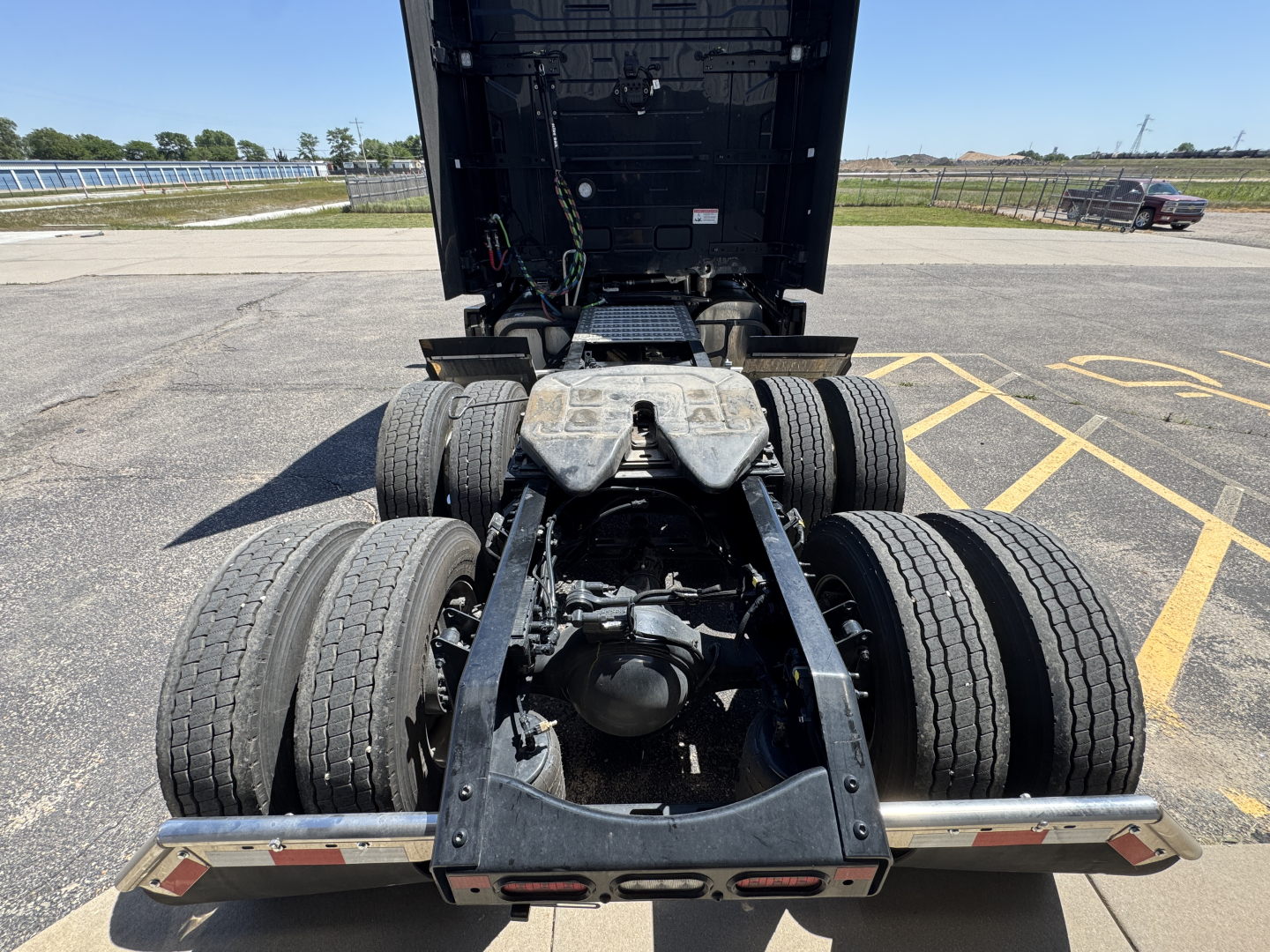 Truck chassis and dual rear axles of a Mack PR64T76H tractor captured from behind, showing the fifth-wheel area and rear tires.
