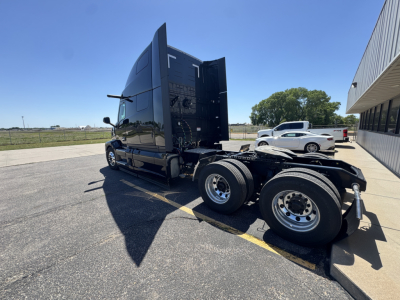 Truck cab and chassis of a new 2027 Mack PR64T76H conventional sleeper with dual rear axles, chrome wheels, and a raised sleeper cab. No identifying stickers readable.
