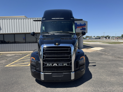 Front view of a black Mack PR64T76H truck cab showing Mack grille with large ‘MACK’ emblem, headlights, and chrome bumper.