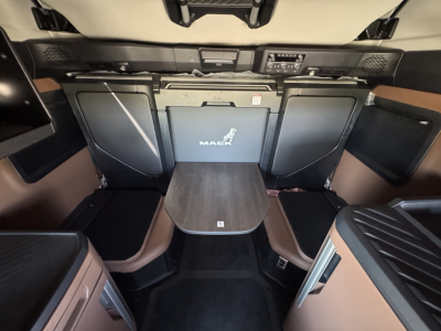 Mack PR64T76H sleeper cab interior showing rear seat area and storage cabinets with Mack logo