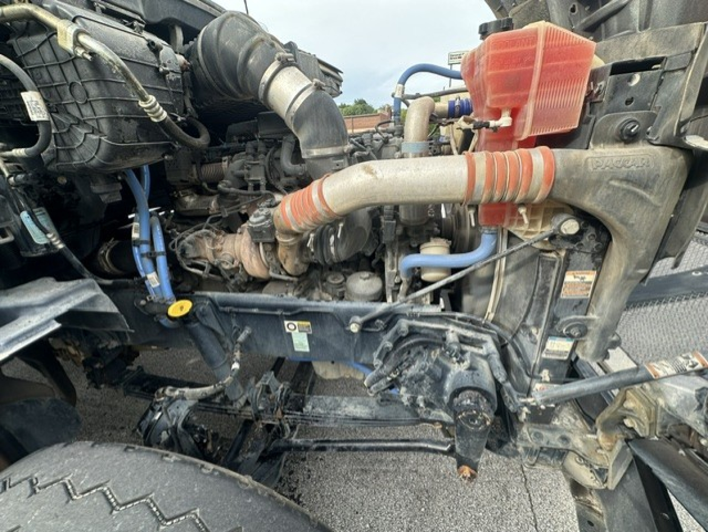 Kenworth T880 engine bay showing turbocharger, hoses, coolant reservoir, and surrounding components.