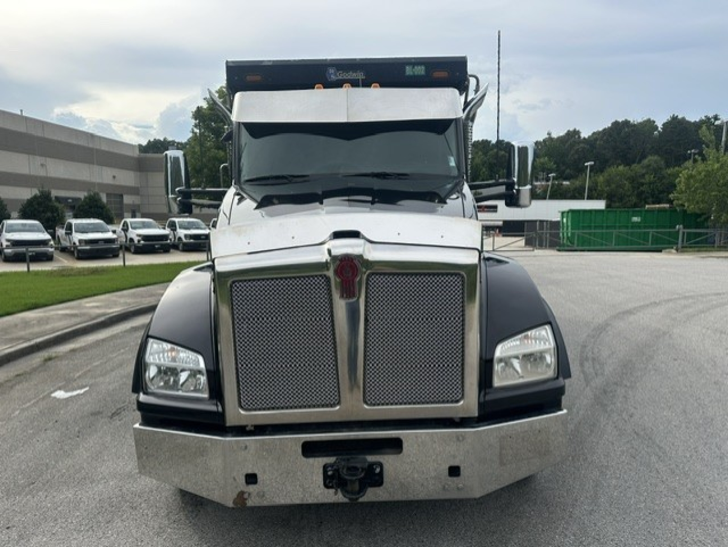 Kenworth T880 front view showing large chrome grille, rectangular headlights, and heavy-duty bumper. Diesel truck with black fenders and hood, side mirrors, and windshield.