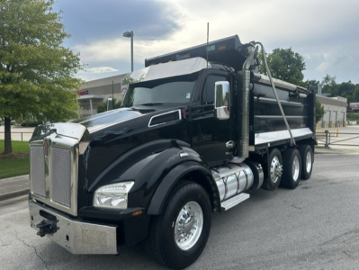 Kenworth T880 dump truck in service showing black cab and dump body with chrome accents.