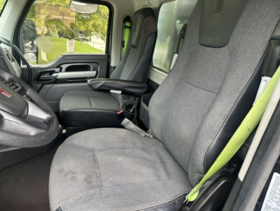 Kenworth T880 truck interior showing front seats and steering wheel, gray fabric upholstery, seat belts, and dashboard view.