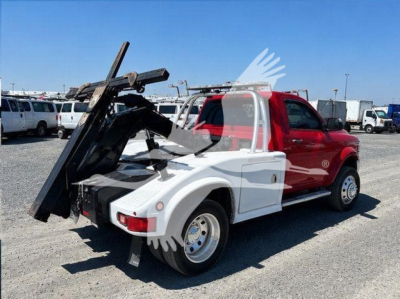 Truck bed winch setup on 2021 Ram 4500 SLT showing hydraulic bed tilting mechanism and dual-tone white and red cab.