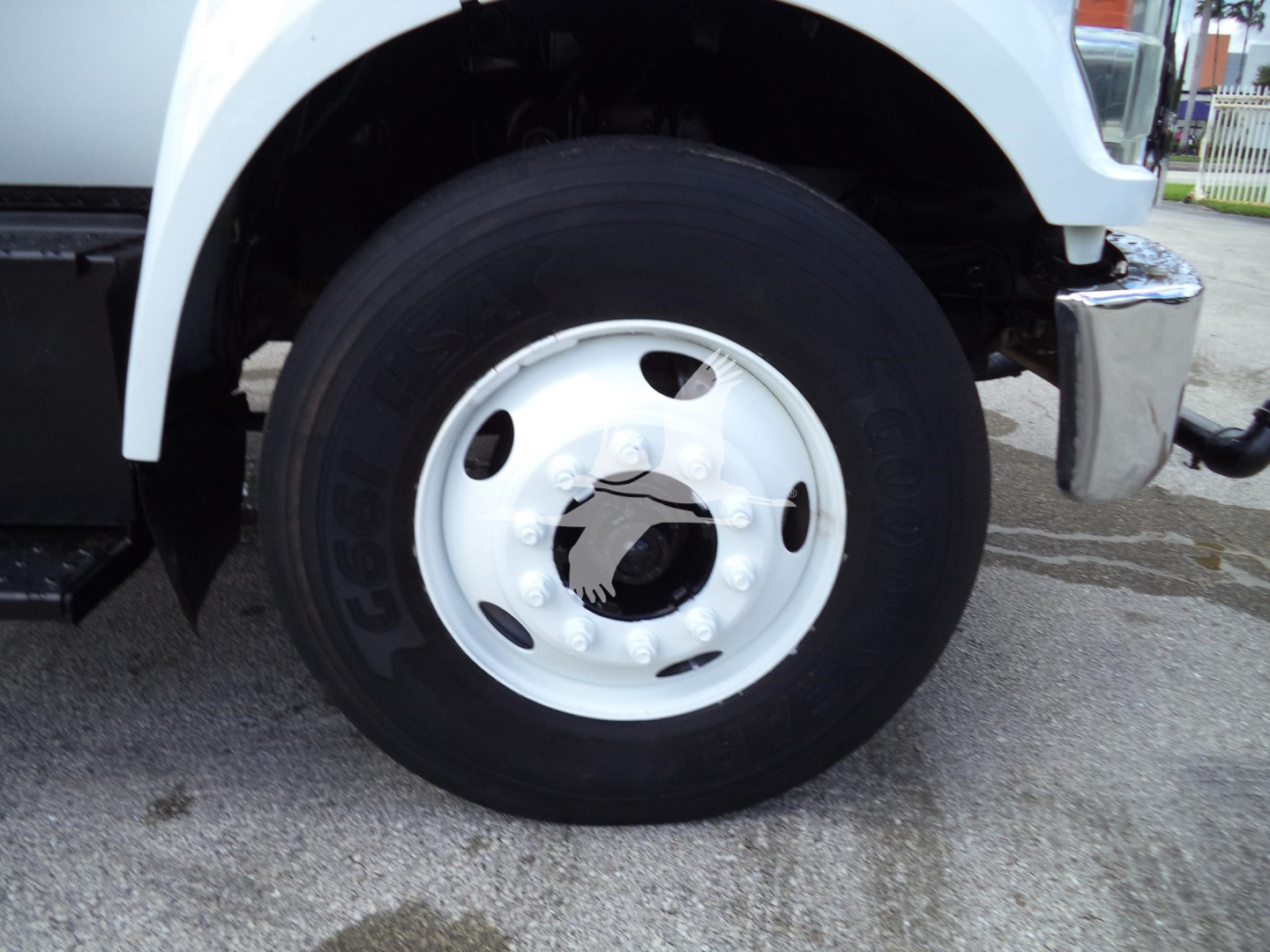 Wheel and front fender of 2017 Ford F650 truck showing tire and white steel wheel with hub; partial chrome bumper and bodywork visible.