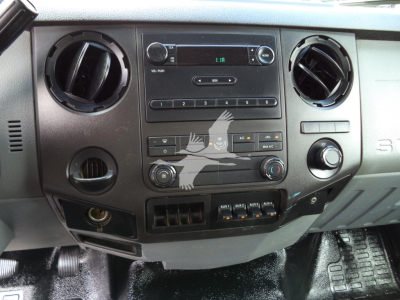 Dashboard of a 2017 Ford F650 truck showing center console with radio, climate controls, circular vents, USB/aux panels, and warning icons.