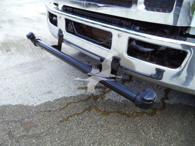 Front view of a 2017 Ford F650 with a long steel front bumper / bumper guard visible and a black cylindrical tow hitch/dolly bar attached under the bumper.
