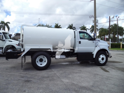 2017 Ford F650 SD stock truck with large white tank on chassis side view in a dealership lot.