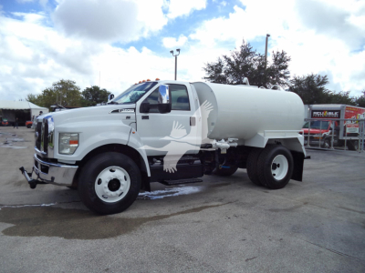 Water tanker truck 2017 Ford F650 Sd with white cab and large cylindrical tanker, side view, stock number T01946FM.