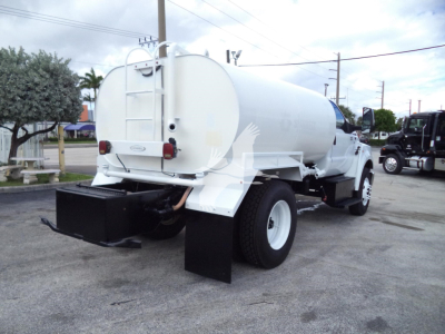 Industrial water tank truck rear view showing cylindrical tank, rear ladder, bumper, and dual rear wheels.