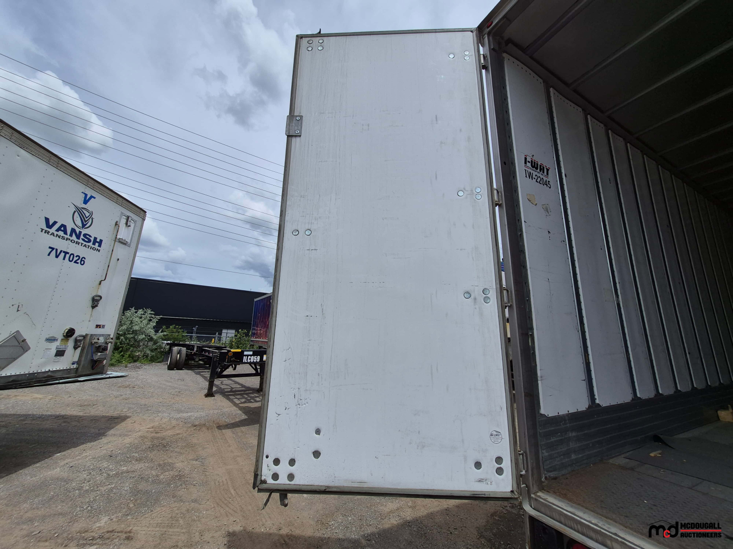 Trailer side and open rear door of a 2022 Utility 53' dry van trailer showing the interior and exterior aluminum panels