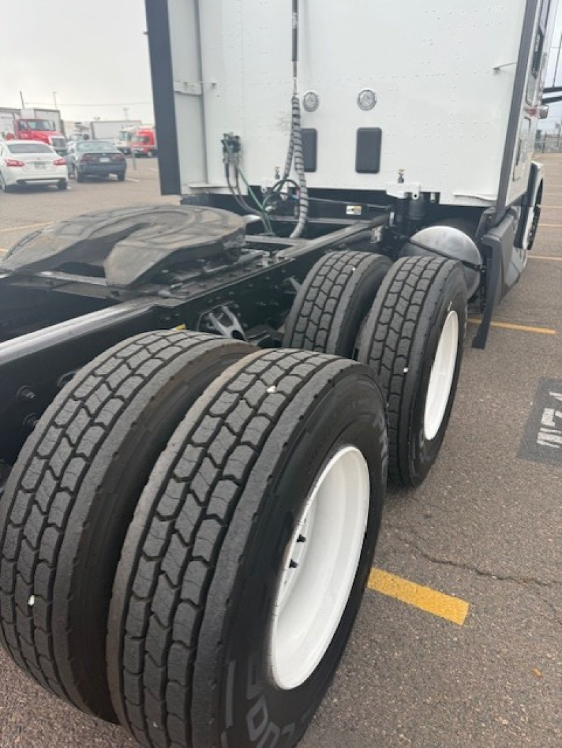 Kenworth T680 rear dual rear axles showing tires and wheel rims in a parking lot.