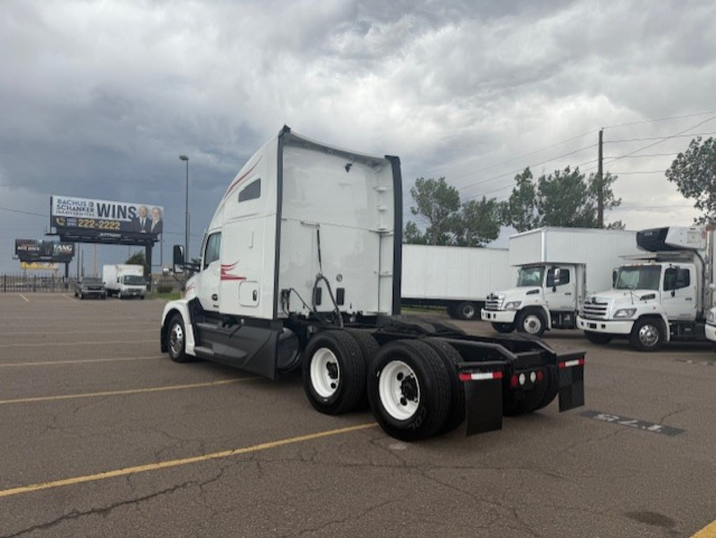 Kenworth T680 truck tractor rear view showing triple axle and white sleeper cab