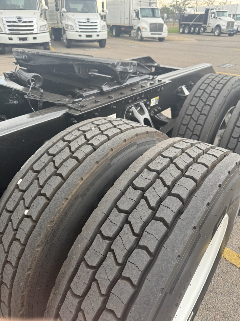 Kenworth truck chassis with dual rear tires and undercarriage view showing frame and suspension components.