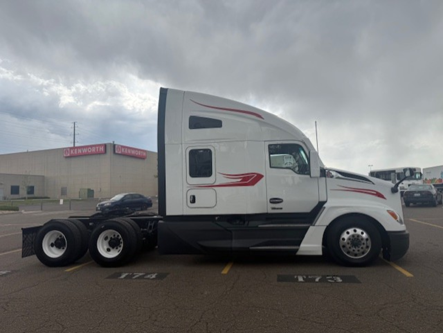Kenworth T680 tractor in a parking lot side view showing sleeper cab and dual rear axles.