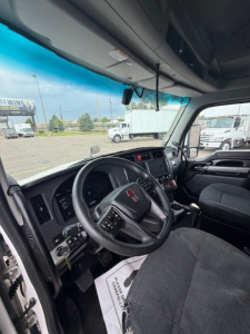 Kenworth T680 dashboard interior view with steering wheel, instrument cluster, and center console in a sleeper cab truck.