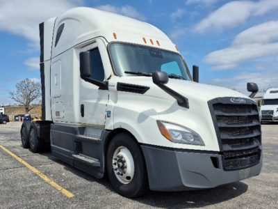 Freightliner Cascadia 126 heavy truck front-right view showing cab, grille, headlights, and side mirror in a parking lot.