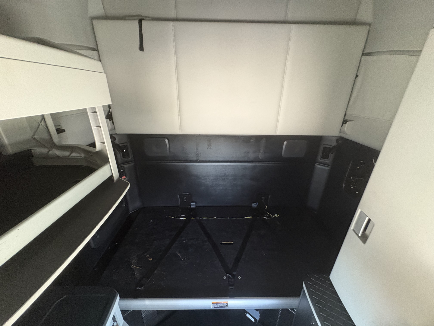 Kenworth T680 cab interior cargo area with flat floor and tie-downs, visible bunk area and side panels.