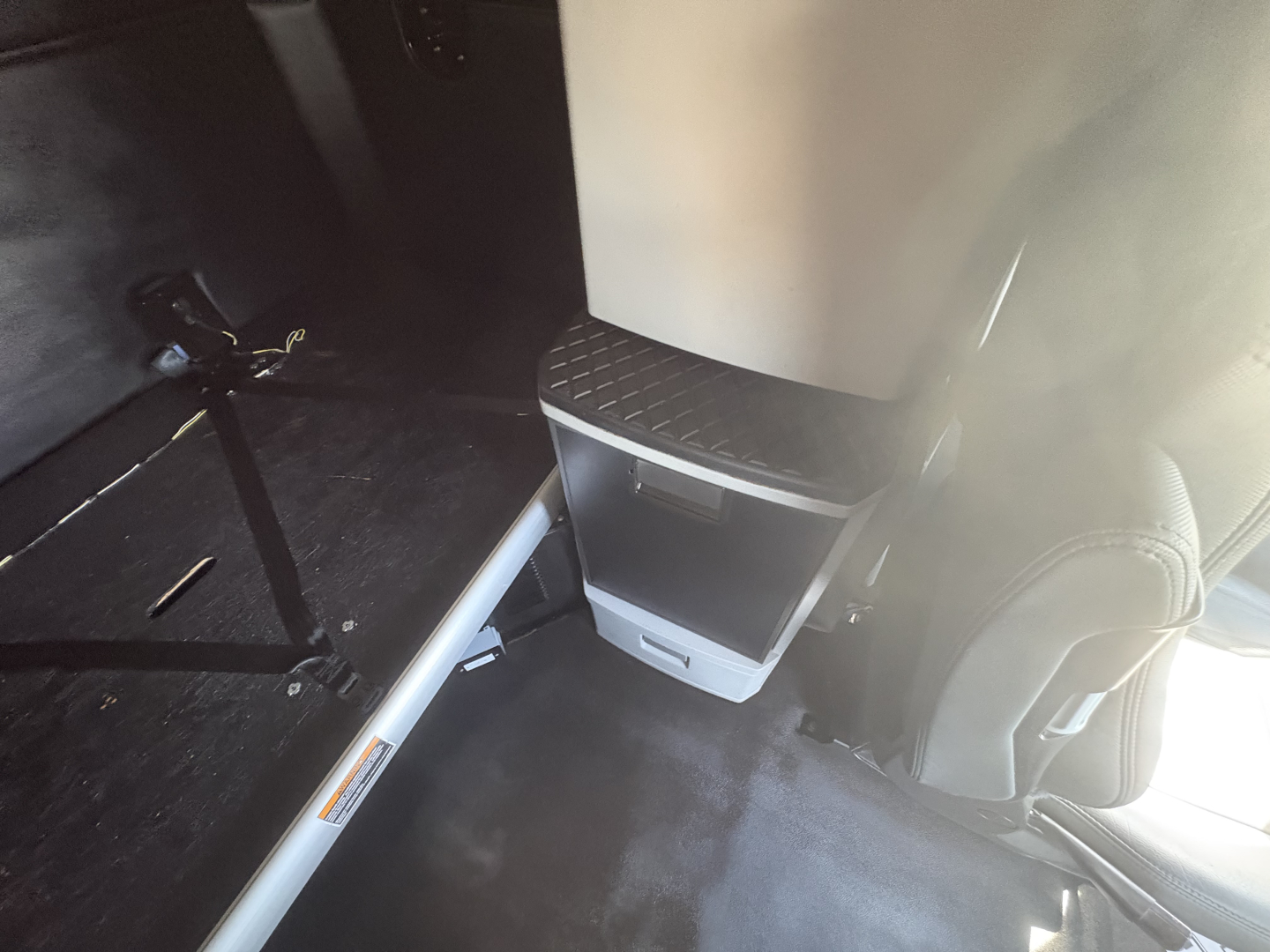 Kenworth T680 cab interior view showing step and lower dash area with metallic step plate and seat edge. Engine bay not visible.