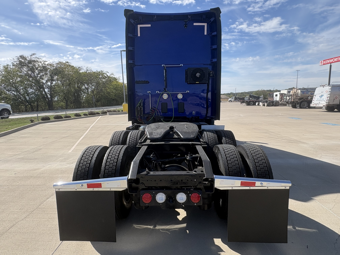 Kenworth T680 rear view showing fifth wheel, dual rear axles, mud flaps, and rear lights.