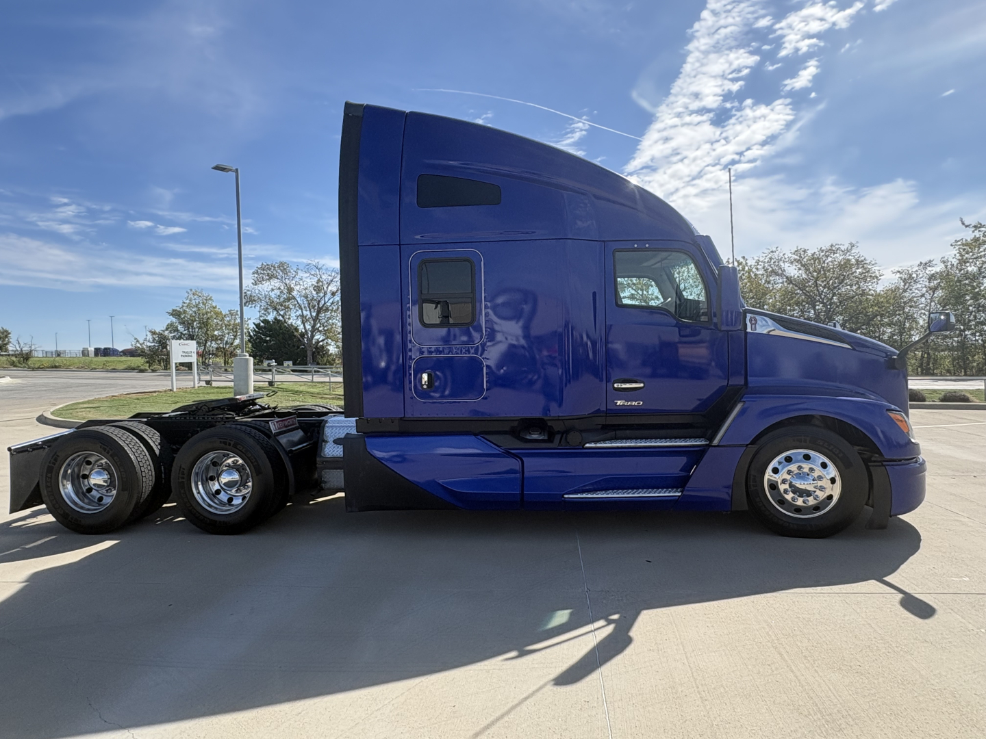 Kenworth T680 conventional sleeper truck side view showing blue color and wheel configuration.