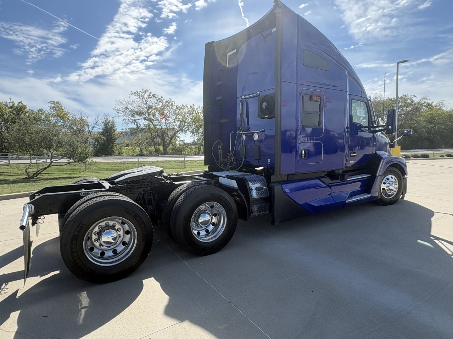 Kenworth T680 tractor cab in blue side view showing rear wheels and sleeper area, no visible text on components.