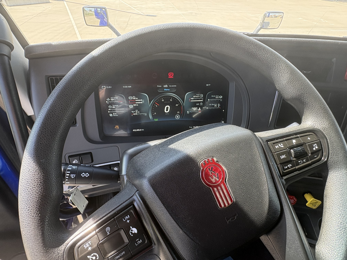 Kenworth T680 steering wheel and digital dash showing instrument cluster, steering controls, and indicator icons.