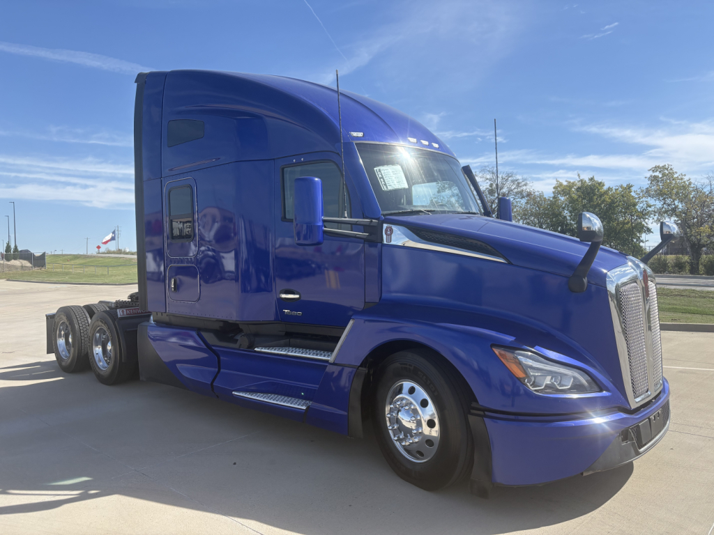 Kenworth T680 blue semi-truck in factory-new paint with sleeper cab, side view showing front grille, headlights, and chrome wheels.