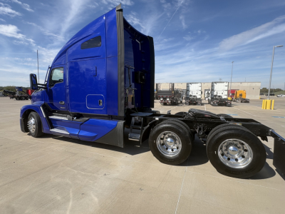 Kenworth T680 truck side view showing blue sleeper cab and rear dual axles