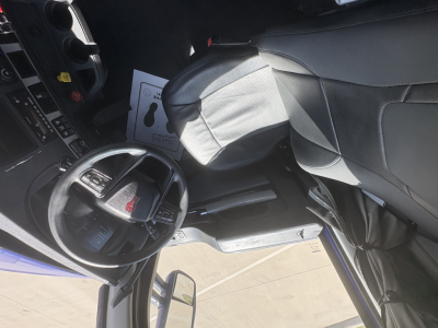 Kenworth T680 dashboard and steering wheel viewed from driver seat with center console and seat in view.