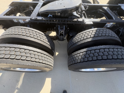 Kenworth T680 chassis and dual rear tires view showing part of the frame and wheel hubs.