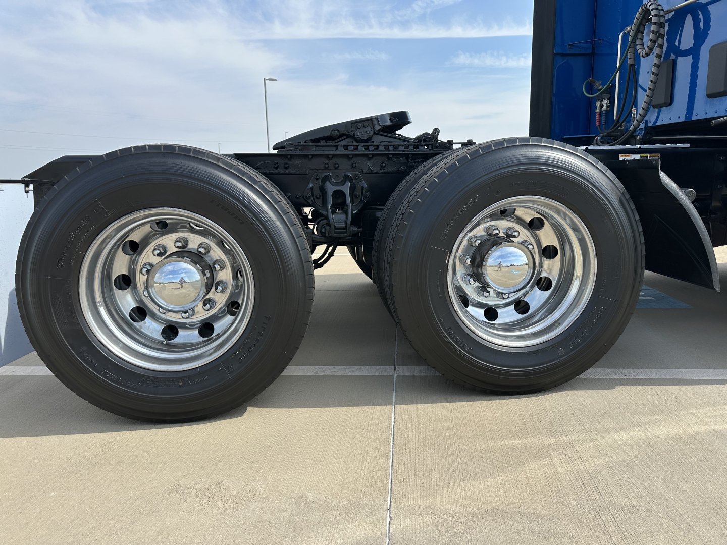 Kenworth T680 dual rear axle wheels with chrome hubcaps and black chassis.