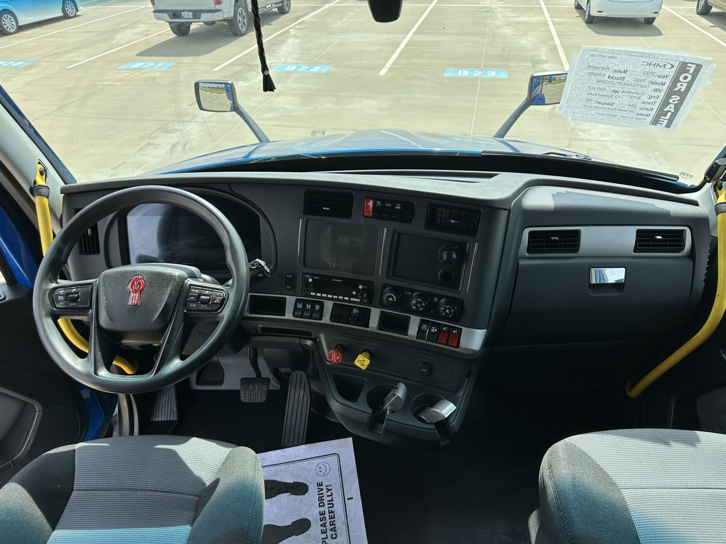 Kenworth T680 truck interior dash and steering wheel view with windshield, driver seat, gauge cluster, and control panel.
