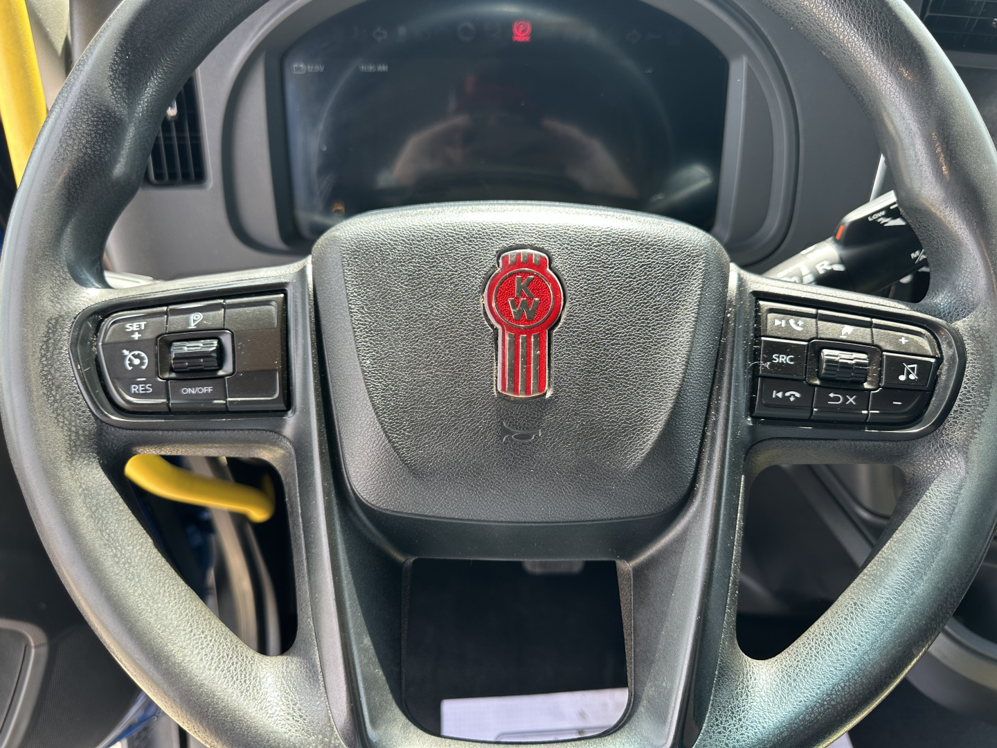 Kenworth T680 steering wheel with KW emblem and dashboard controls in view