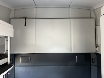 Kenworth T680 cab interior rear sleeper area with storage box and panels visible.