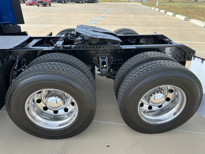 Kenworth T680 chassis showing dual rear axles with large dual tires and chrome wheels.